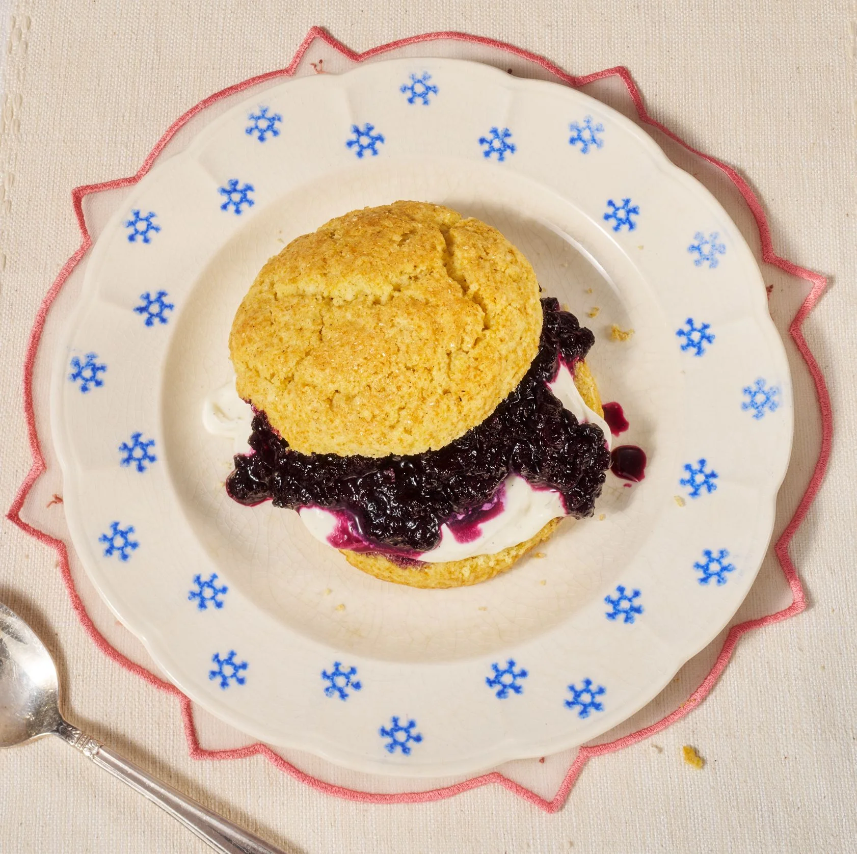 Blueberry Corn Shortcakes deliciously falling over on a plate.