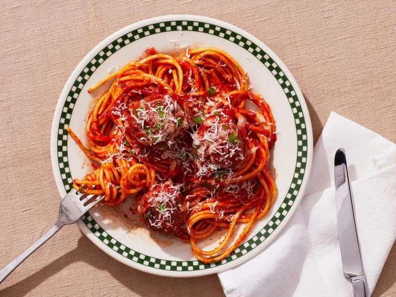 Spaghetti and Meatballs in a bowl with utensils to both sides