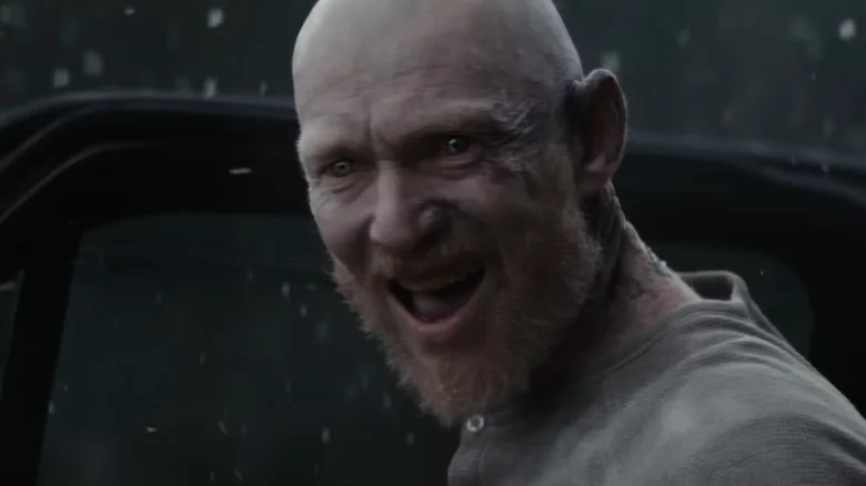 Erroll Shand as Edgar standing by the car door in the snow in Evil Dead Burn