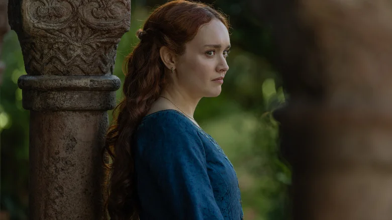 Olivia Cooke as Alicent Hightower wearing a blue dress and standing next to a pillar outdoors in House of the Dragon