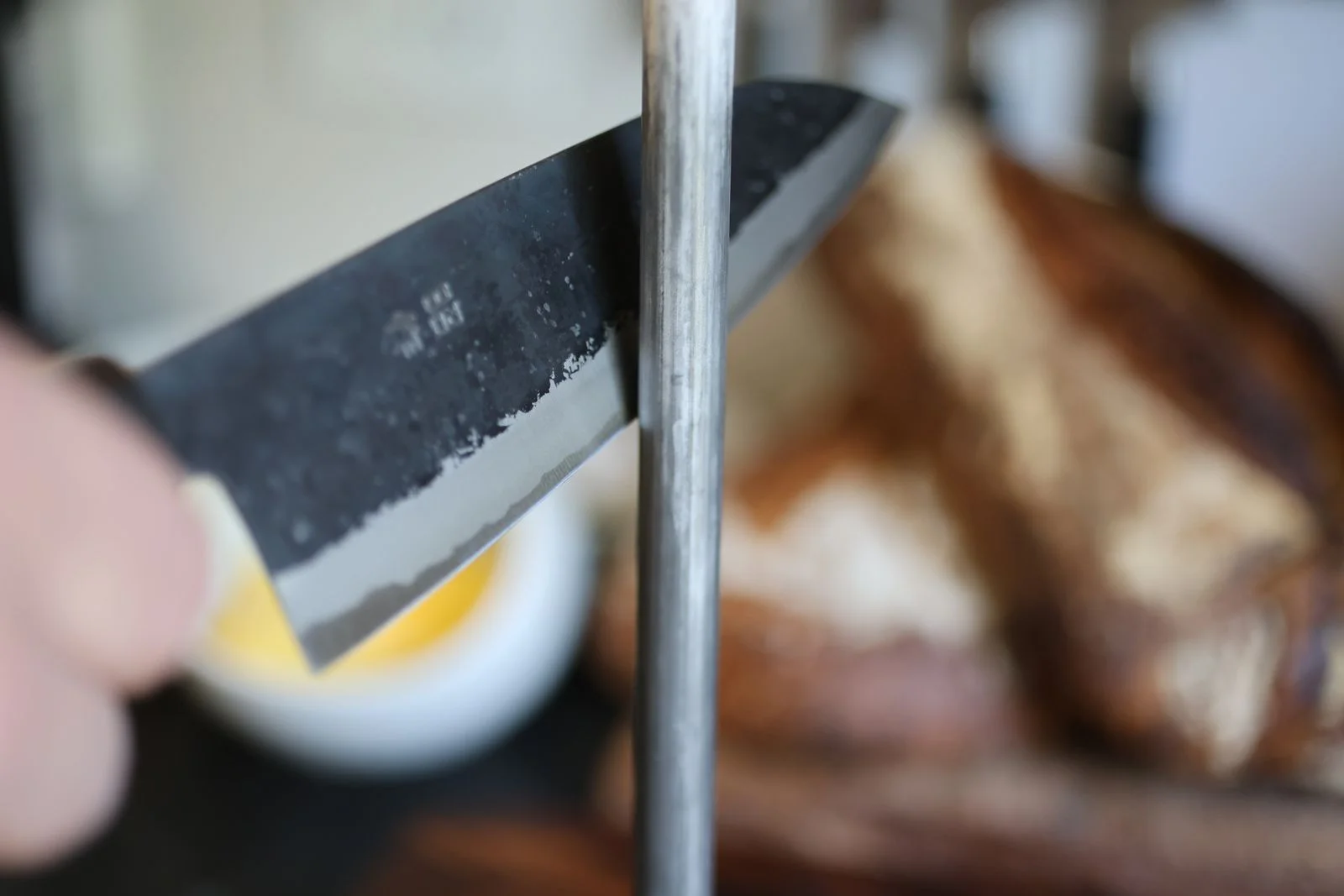 close up sharpening a knife on a ceramic honing rod