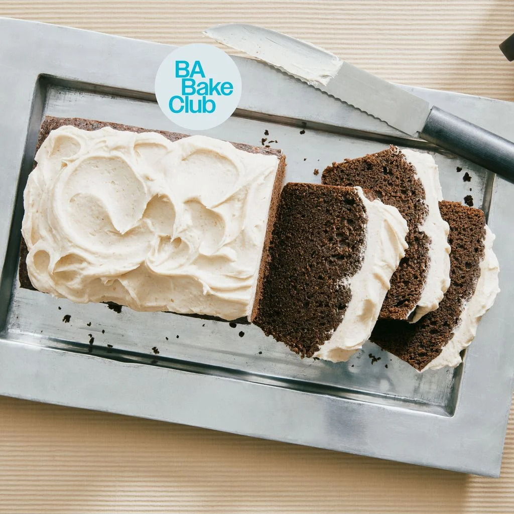 A chocolate loaf cake made with Guinness stout and topped with brown butter frosting sliced up on a serving platter with...