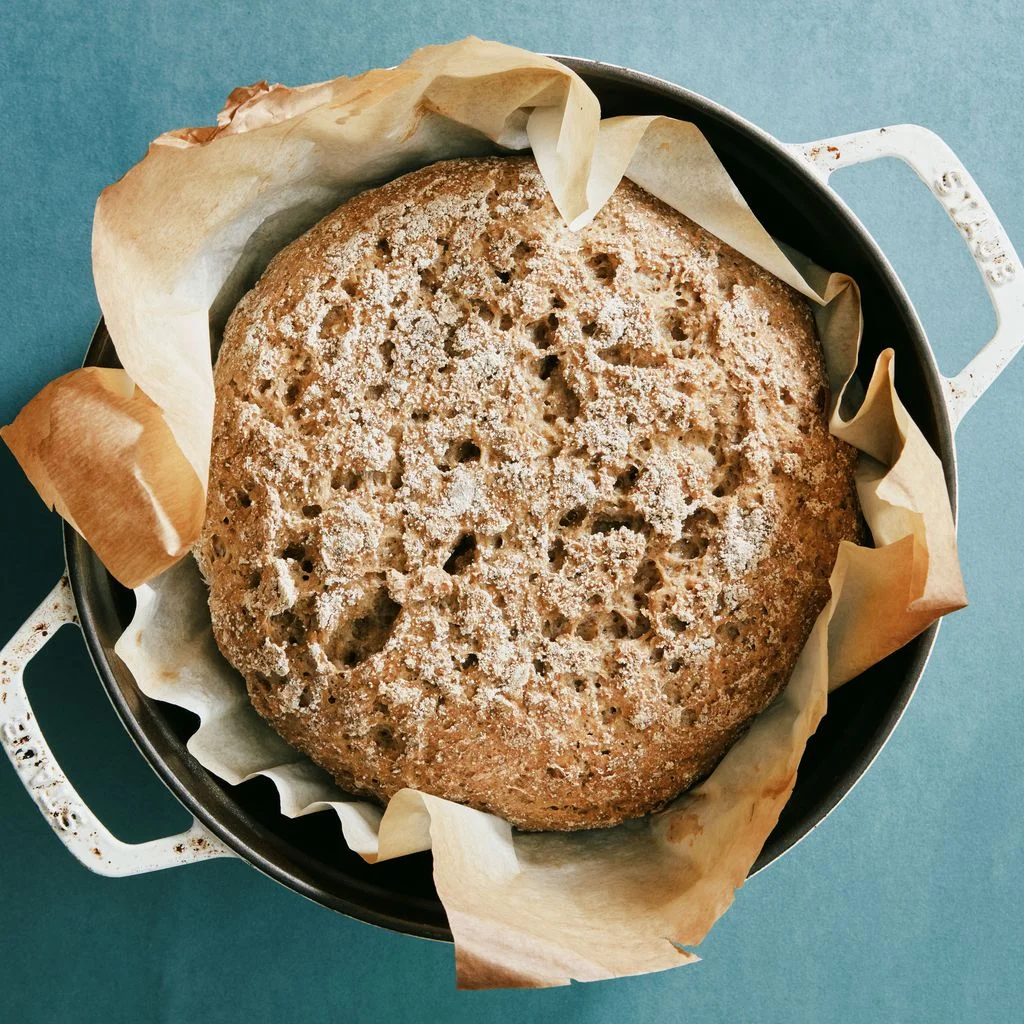 A glutenfree boule with chia seed flour resting in parchment paper in a Dutch oven.