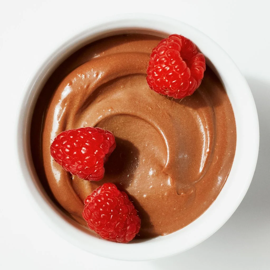 A bowl of mousse made from silken tofu and bittersweet chocolate chips topped with raspberries.