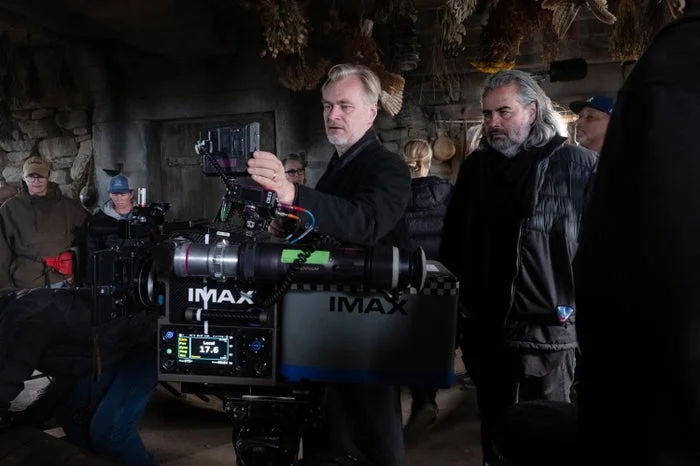 Filmmaker directs a scene on a movie set, surrounded by crew and cameras
