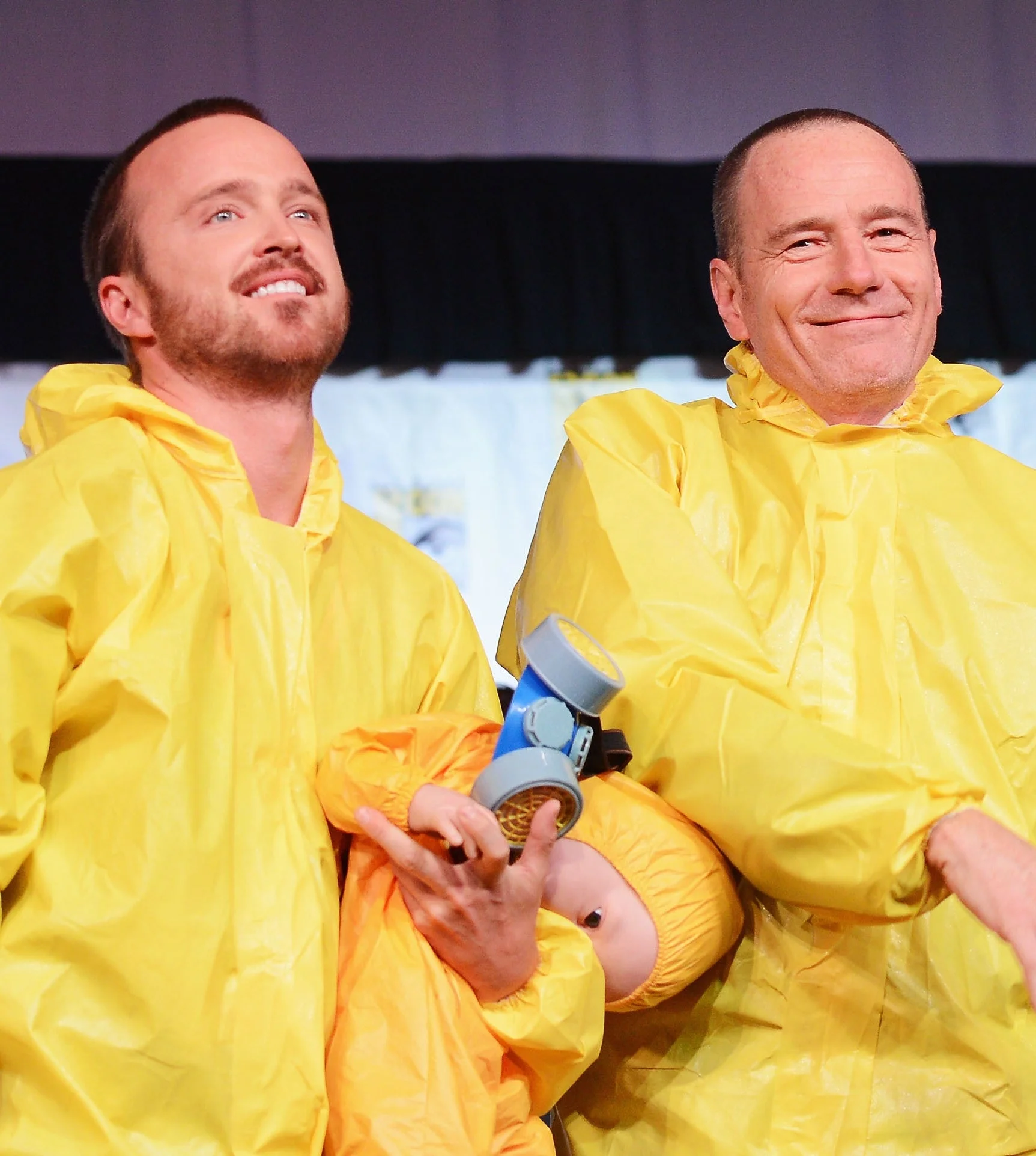 Aaron and Bryan wearing yellow hazmat suits on stage