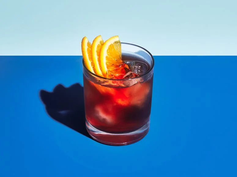 Negroni cocktail with a light blue and dark blue background.