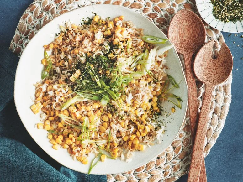 Sweet corn fried rice furikake and thinly sliced scallions in a serving bowl.