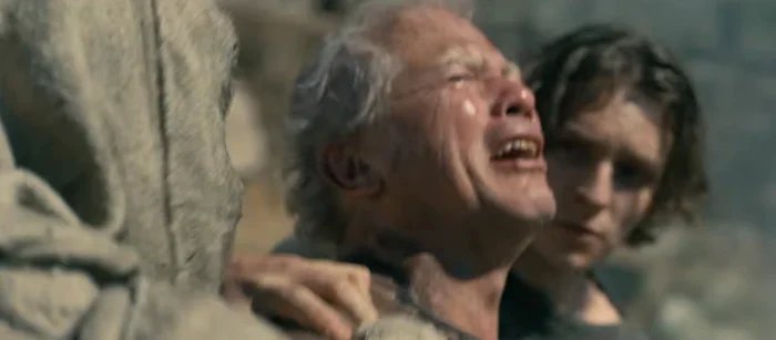 An emotional scene from a dramatic TV series, featuring an older man being supported by a younger person