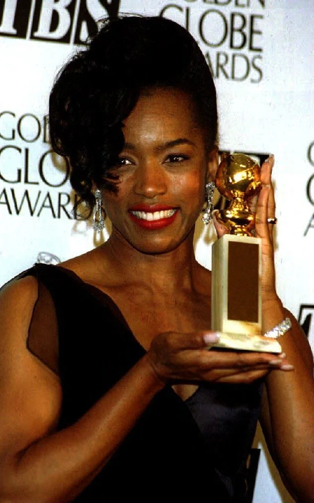 Angela Bassett smiles with her Golden Globe Award for Best Actress in a musical