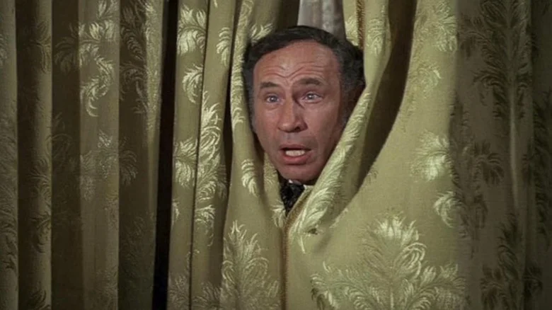 Mel Brooks peeks out from a curtain as Governor William J. Le Petomane in Blazing Saddles