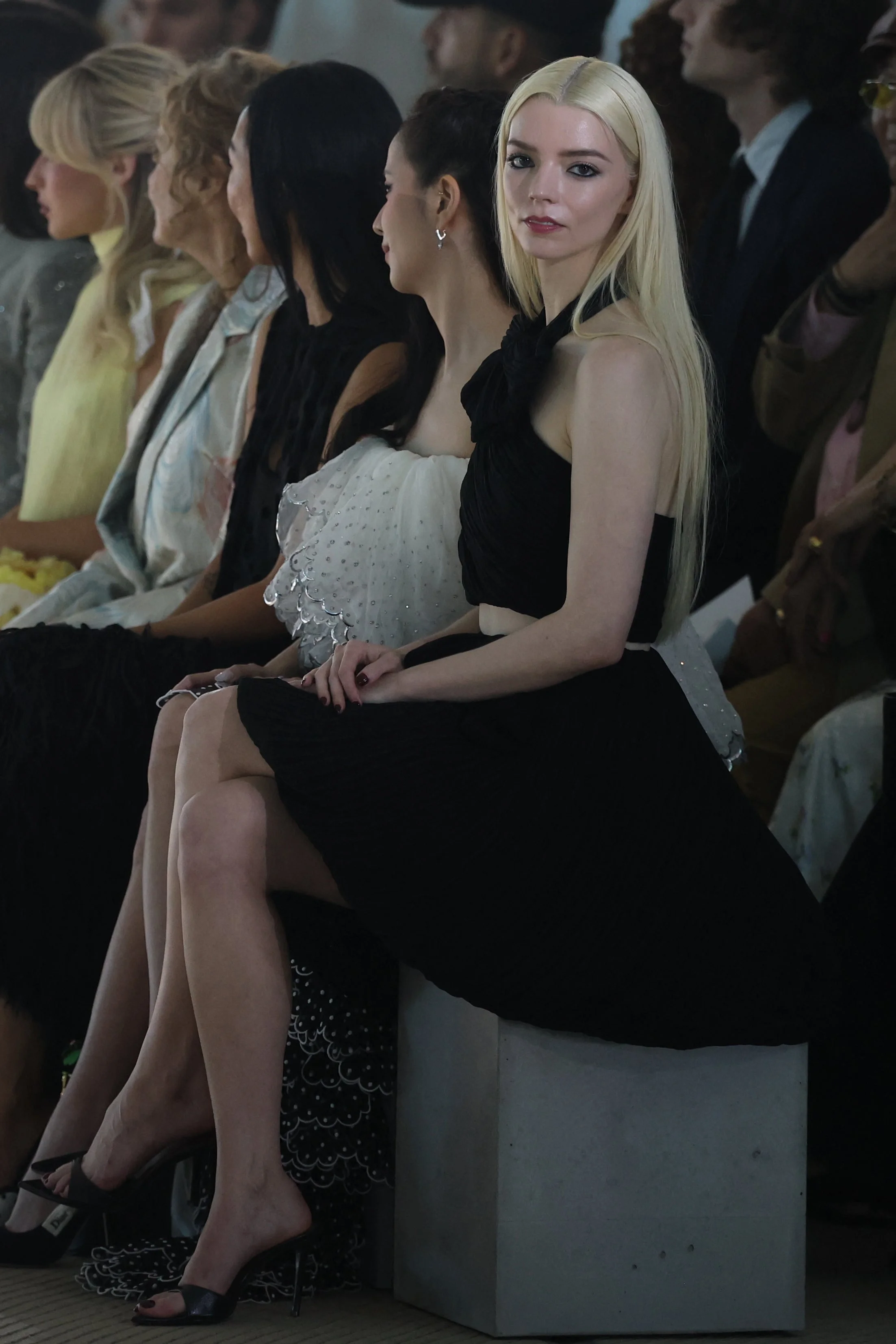 Anya at the fashion show wearing a chic black dress