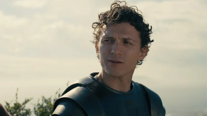 An actor dressed in medieval armor, deep in conversation outside