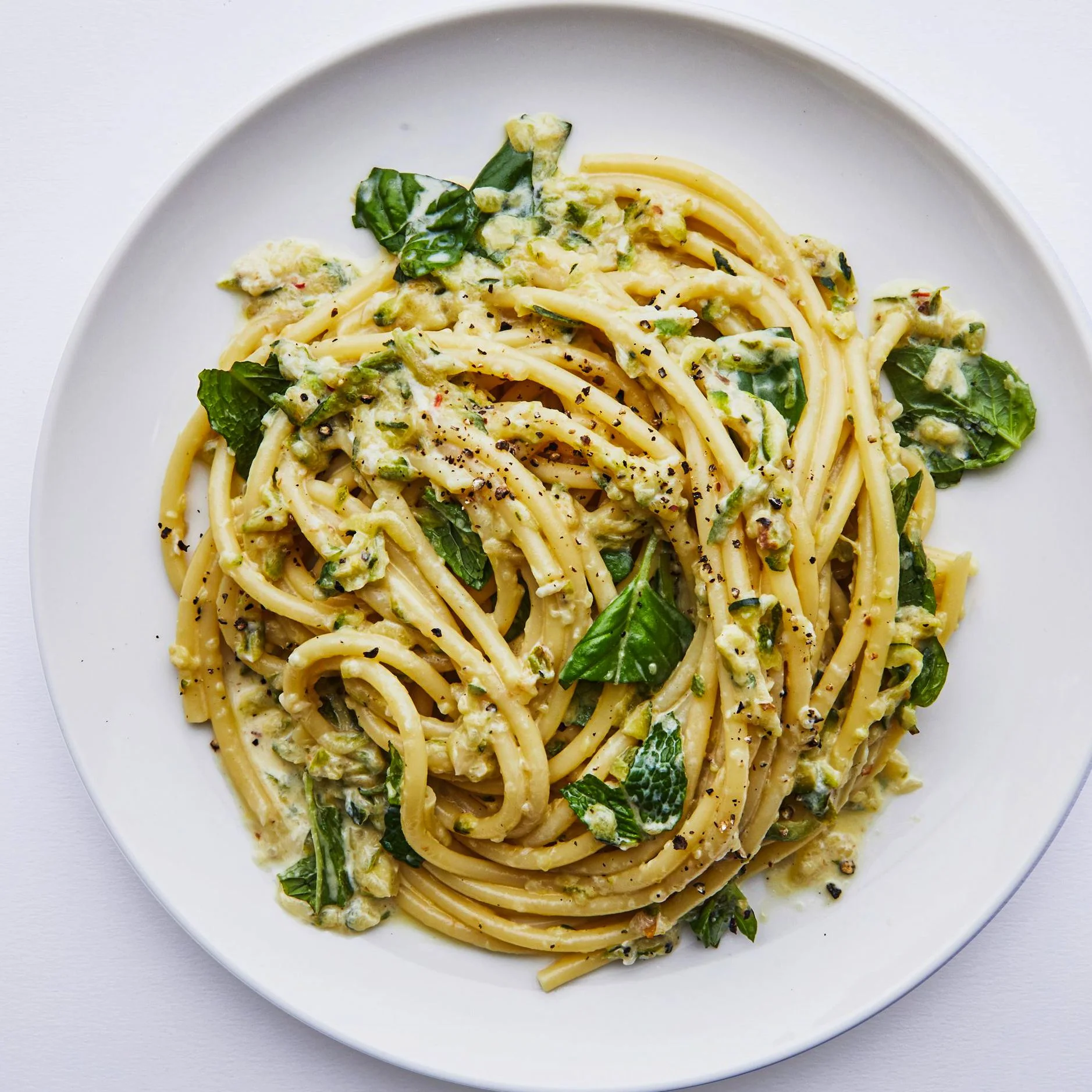 Bowl of creamy lemon zucchini pasta with basil and mint.