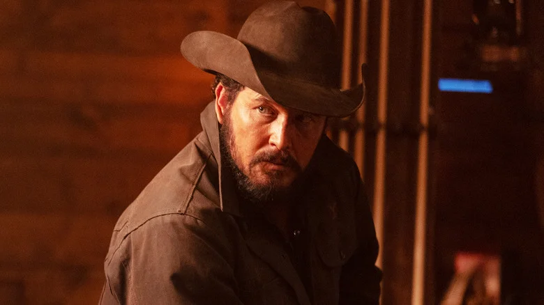 Cole Hauser's Rip Wheeler looks off to his right as he sits in a cabin in Dutton Ranch