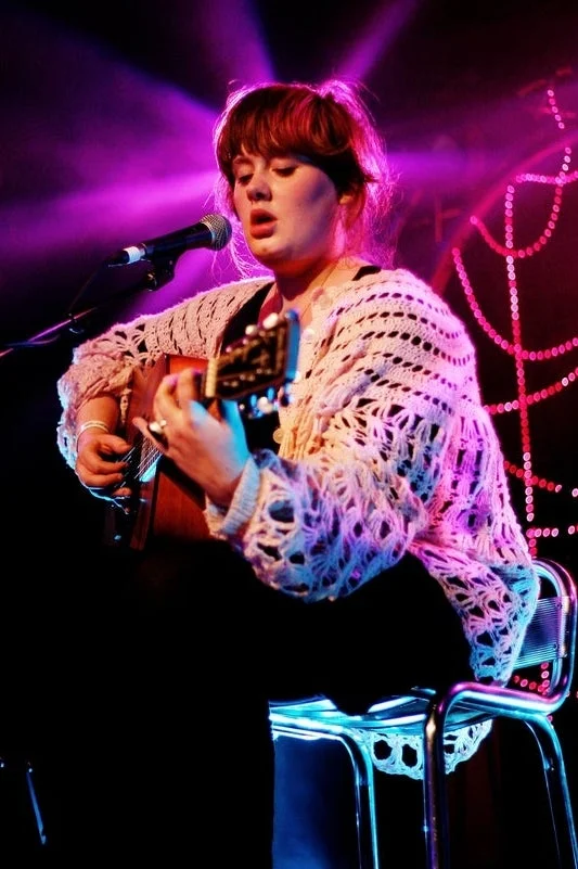 Adele performing with an acoustic guitar