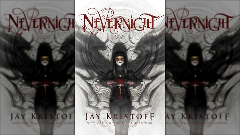 Mia Corvere standing in a mask holding a knife with shadow wings on the wall behind her on the cover of Nevernight