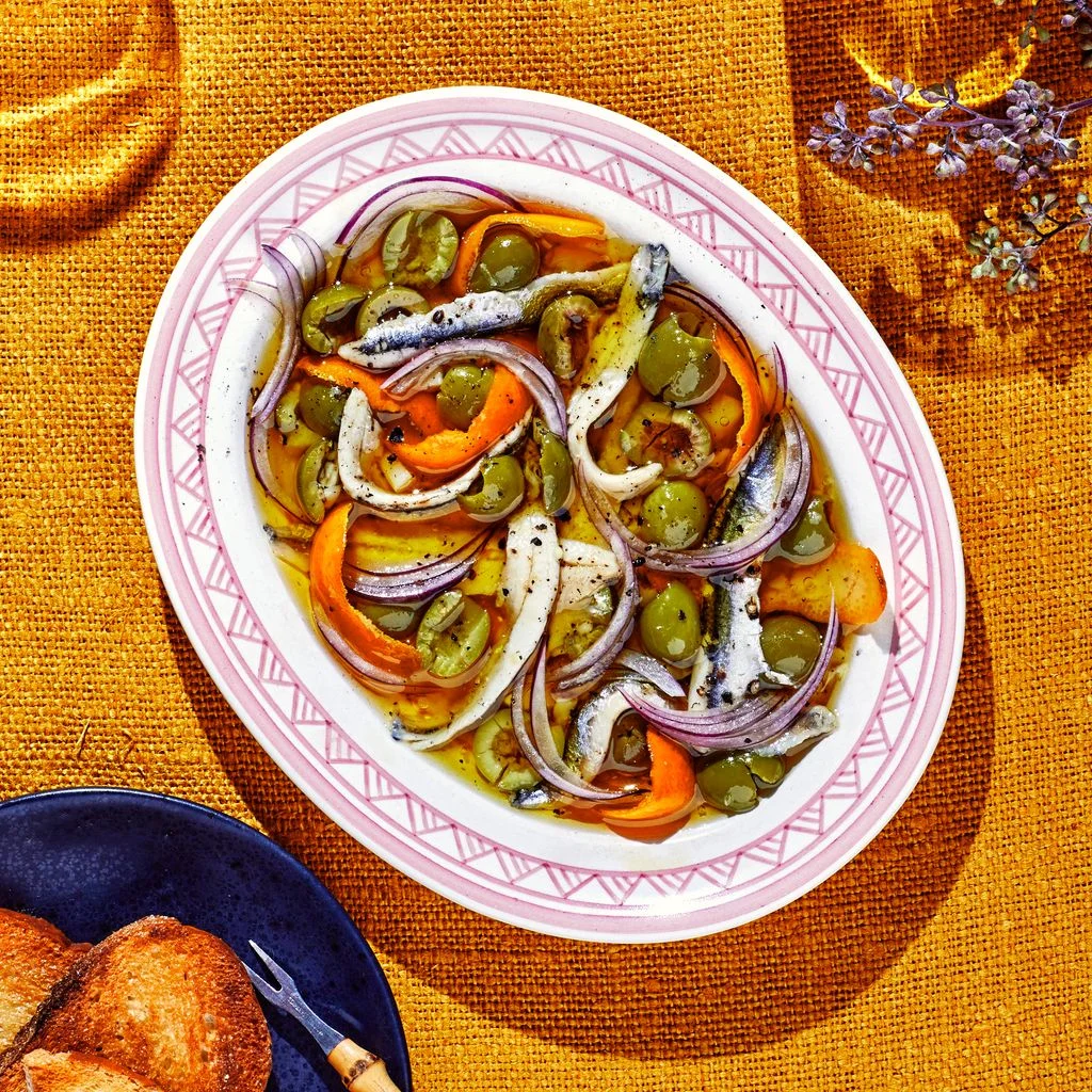 Boquerones With Green Olives and Orange served in a shallow bowl