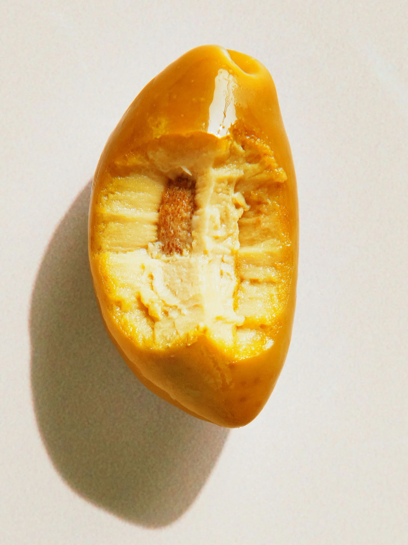 A single cerignola olive with a bite taken out.