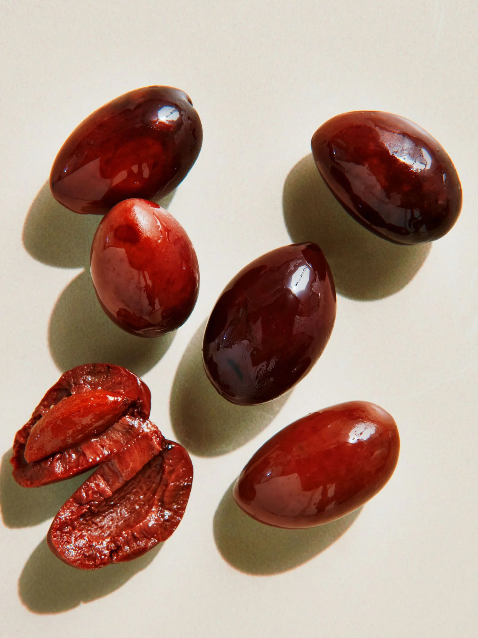 Five reddishblack Kalamata olives one torn in half