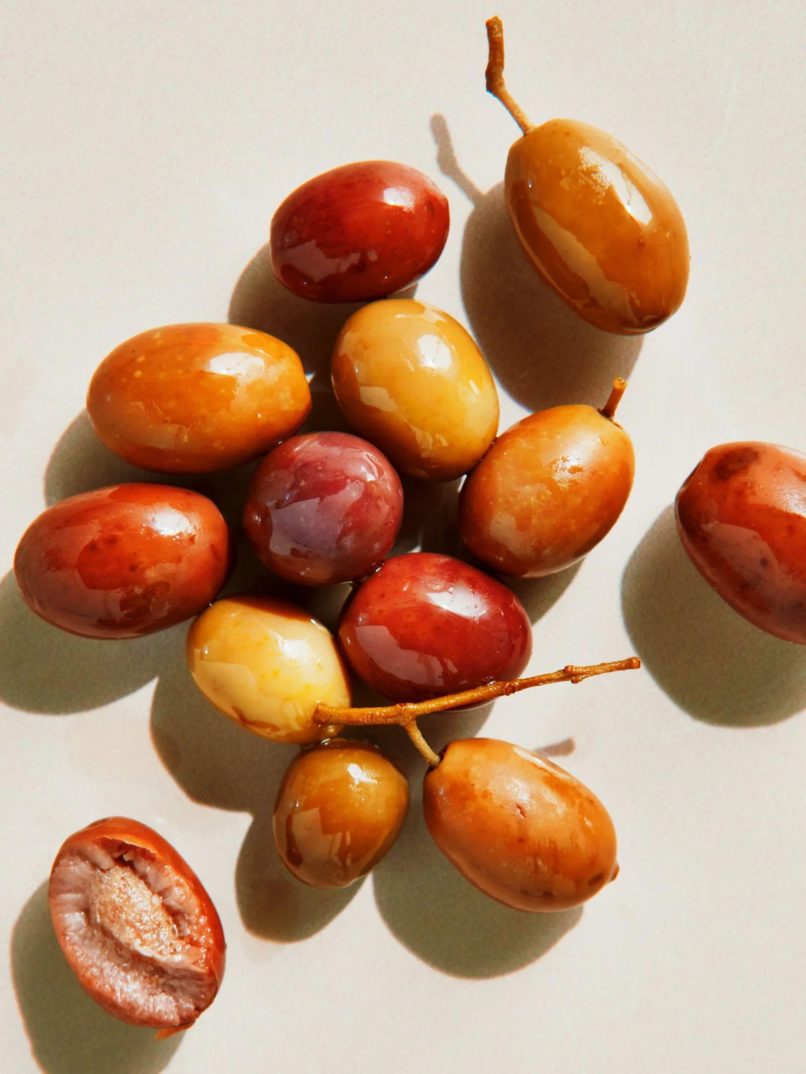 A pile of Niçoise olives in varying shades of brown and green.
