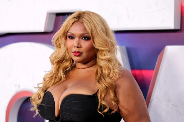 Lizzo wearing a sleek strapless dress at a celebrity event