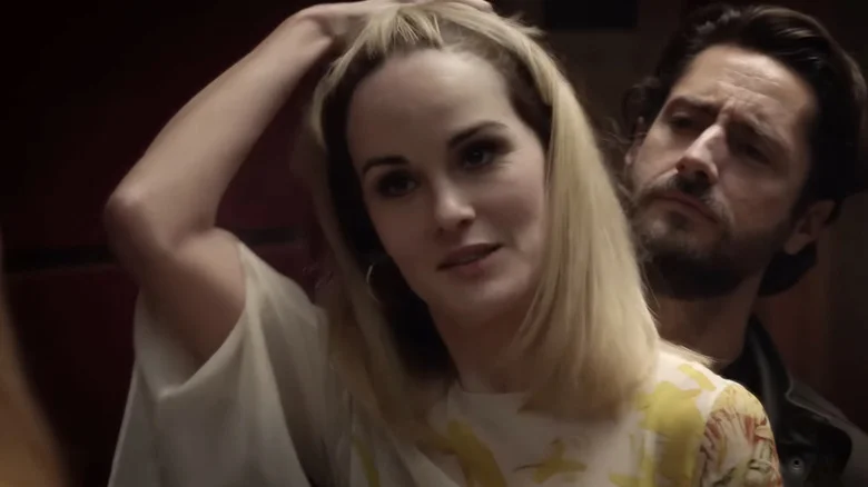 Michelle Dockery's Leticia Raines stands holding her hair in front of Juan Diego Botto's Javier Pereira in Good Behavior