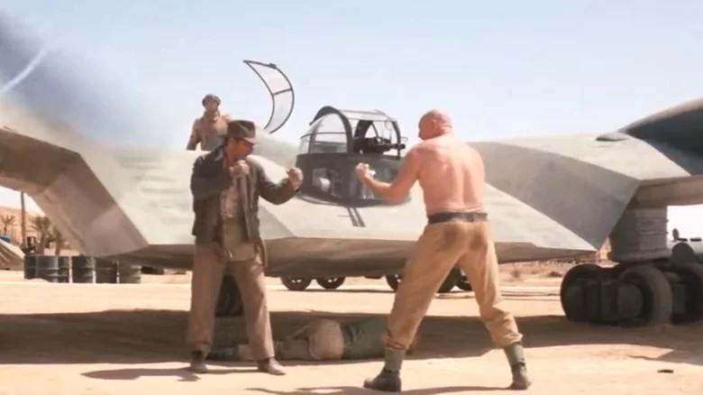 Harrison Ford's Indiana Jones squares up to Pat Roach's German Mechanic next to an airplane in Raiders of the Lost Ark