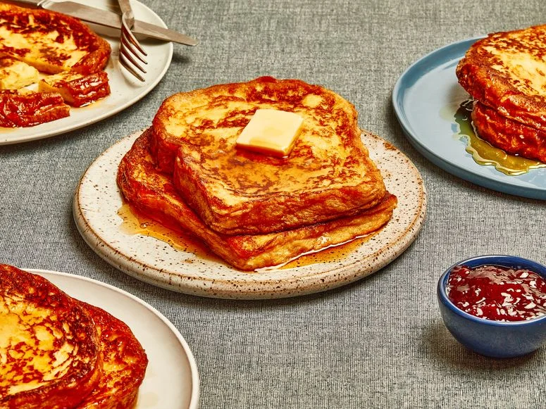 French Toast on a plate with syrup with jam to the side