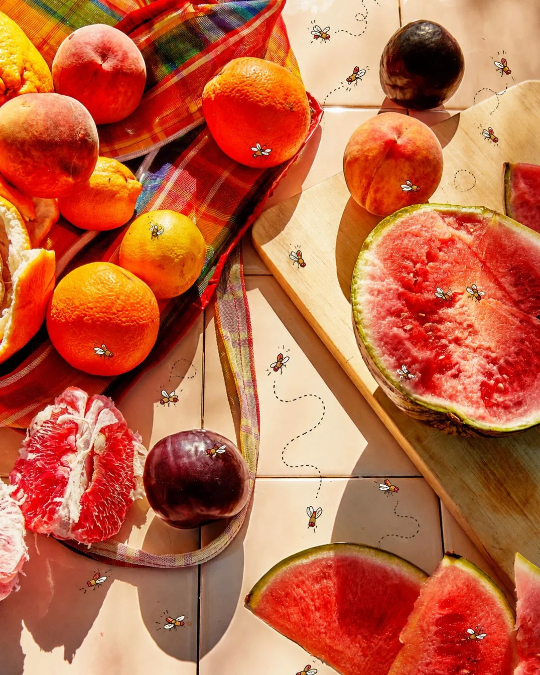 A composite of cartoon fruit flies buzzing around cut watermelon ripe peaches and plums and grapefruit.