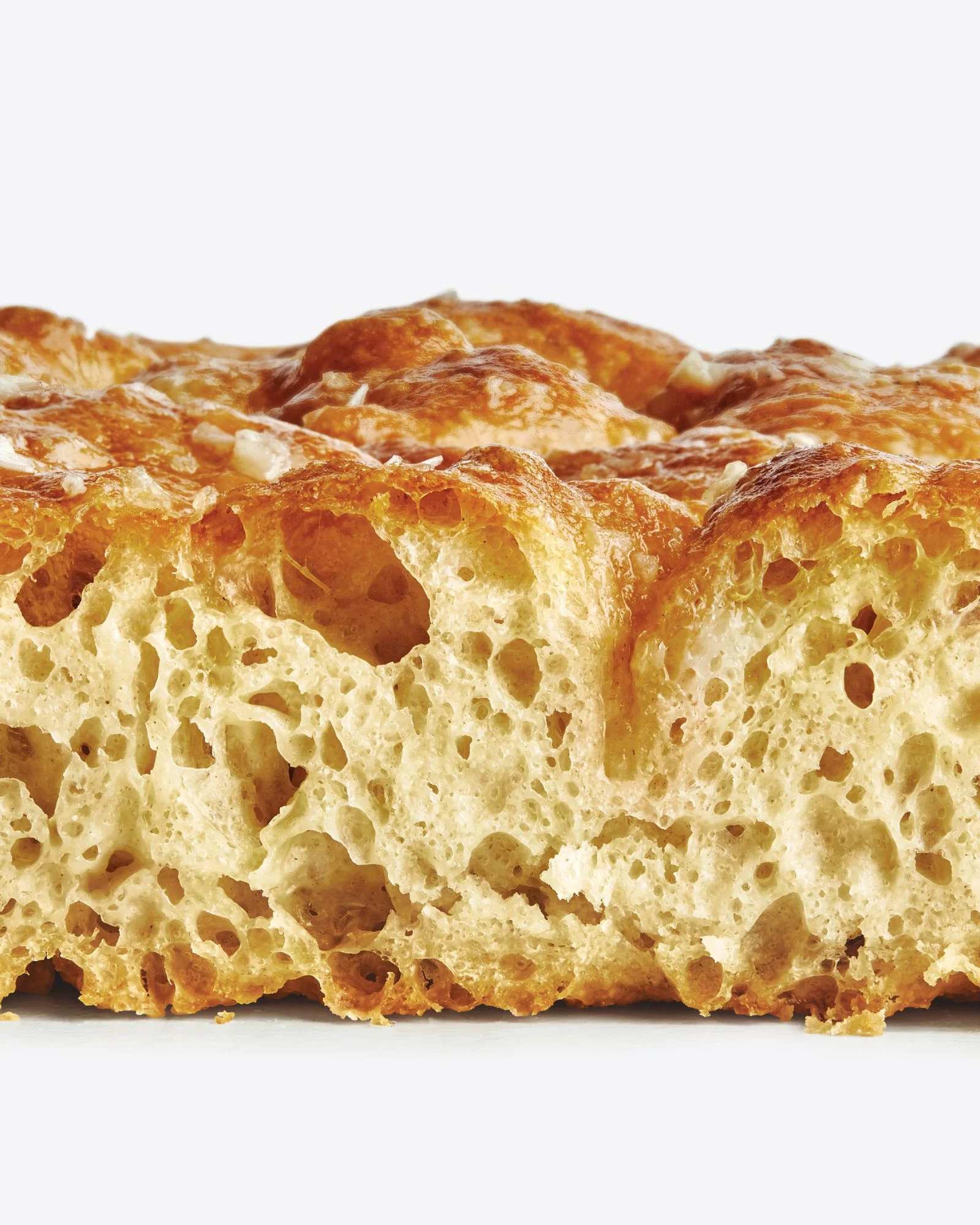 Freshly baked noknead focaccia brushed with garlic butter and sprinkled with flaky sea salt.