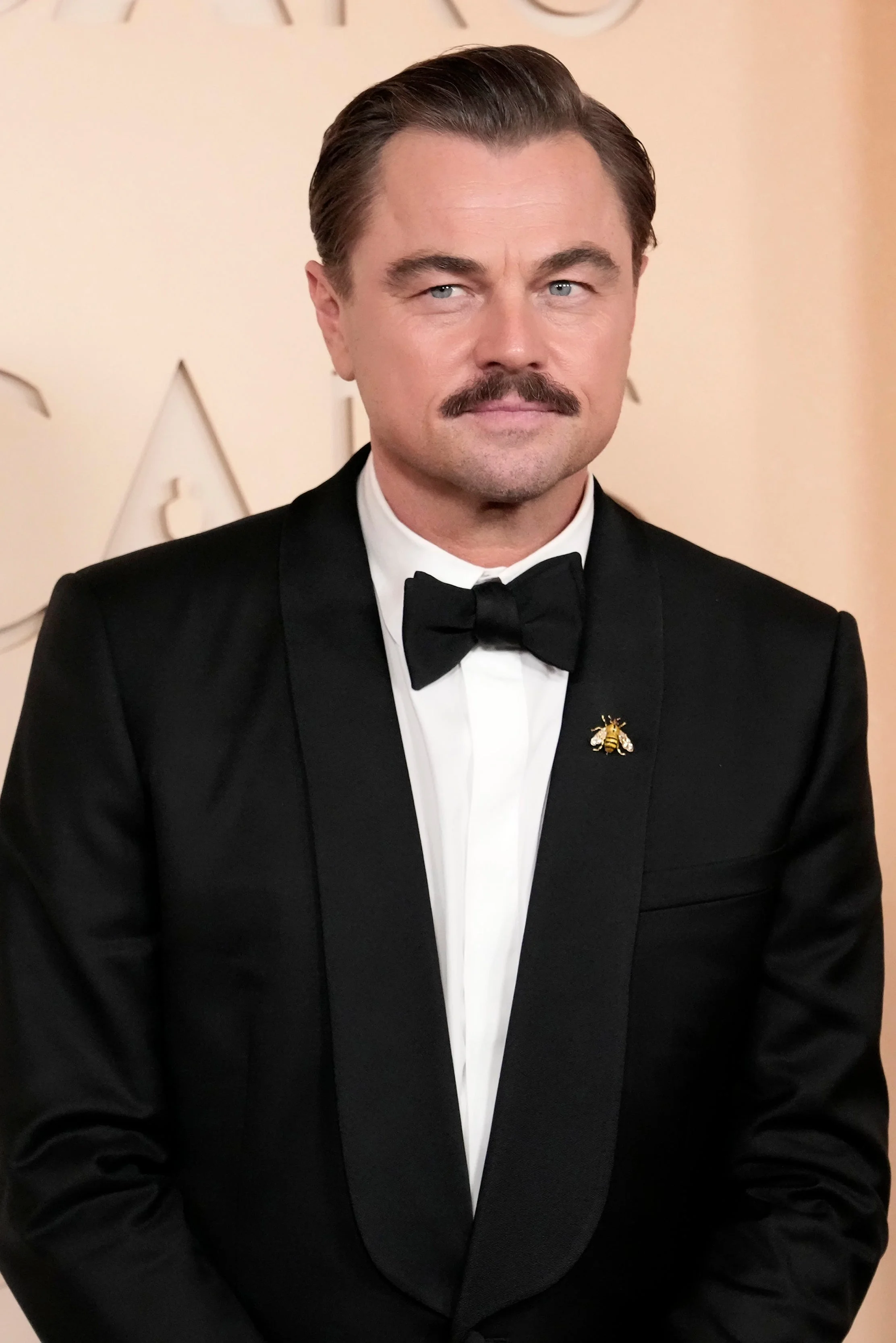 A celebrity in a classic tuxedo poses at a formal event