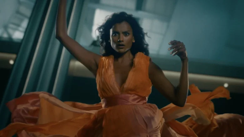 Simone Ashley's Mia is seen falling while wearing an orange dress in This Tempting Madness