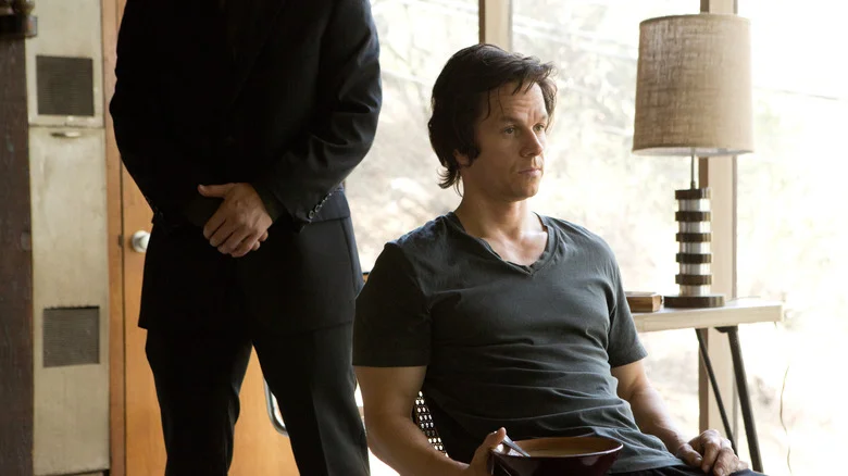 Jim Bennett sitting in a chair with a tough guy behind him in The Gambler