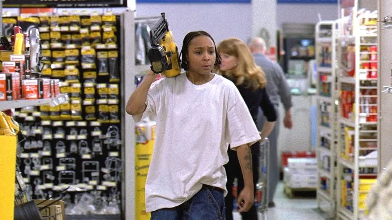 Felicia Pearson as Snoop walking through a hardware store and holding up a nail gun in The Wire