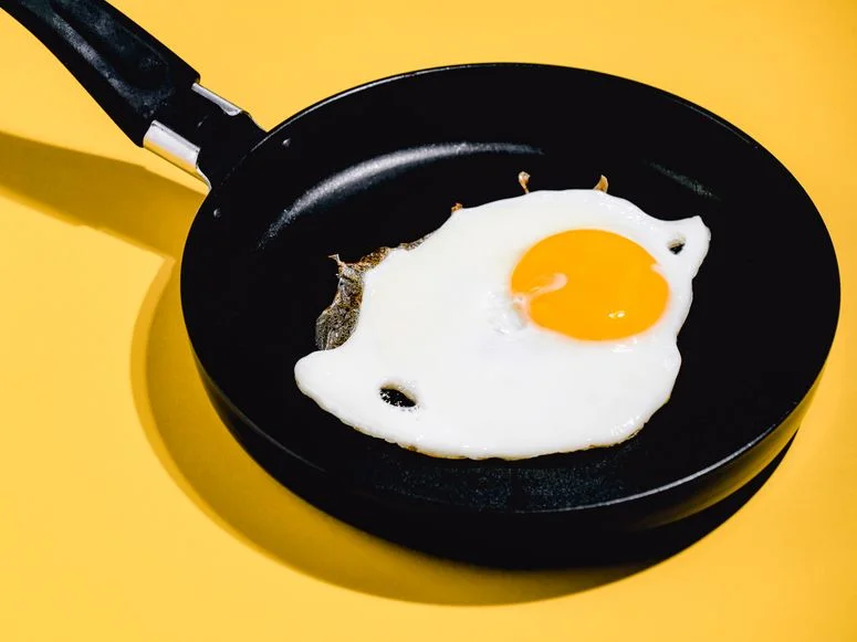fried egg on black pan. top view photography. hen egg, breakfast food.