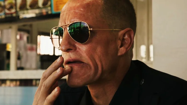 Woody Harrelson's David Brown rubs his lip as he sits in a restaurant in Rampart