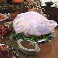 A frozen turkey on a set Thanksgiving table.