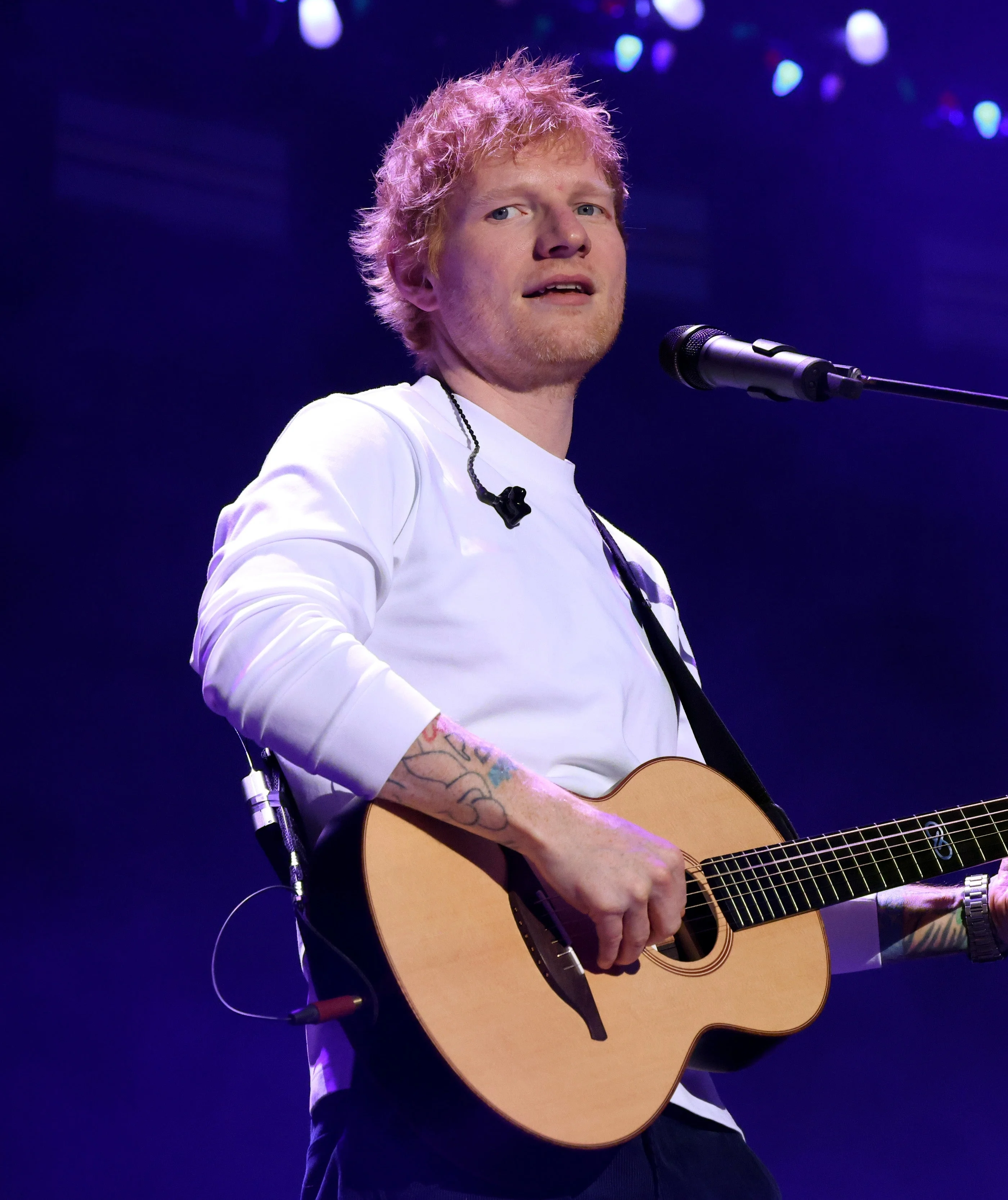 Ed Sheeran with a guitar on stage